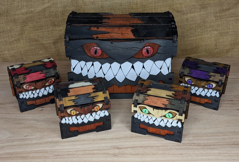 Assorted handcrafted wooden mimic boxes inspired by fantasy creatures, including small and large designs for tabletop RPG storage.