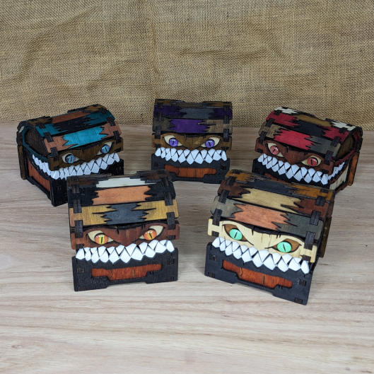 Collection of small handcrafted wooden mimic chests displayed together, featuring varied fantasy creature designs.